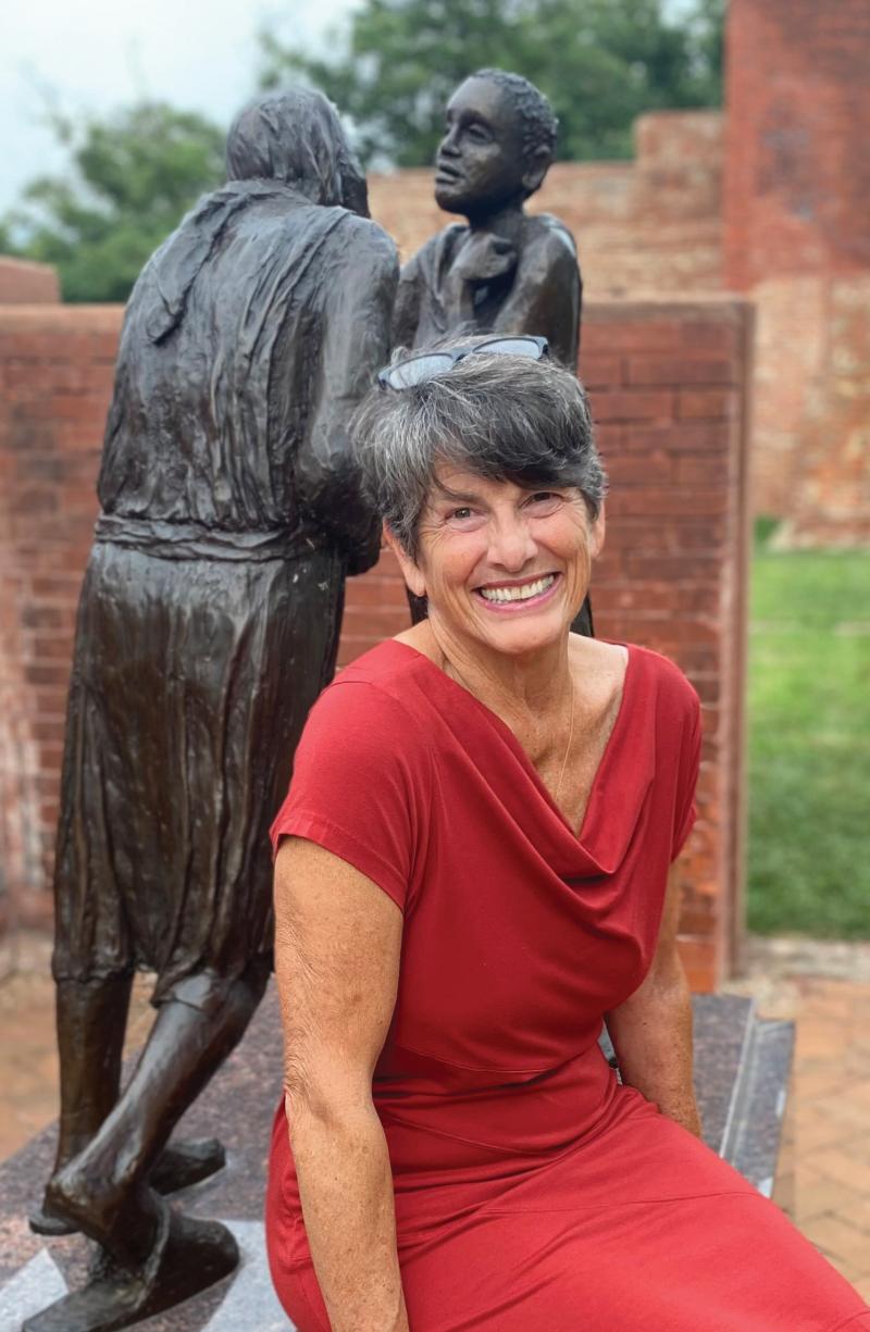 Carolyn Hart sitting in front of a statue
