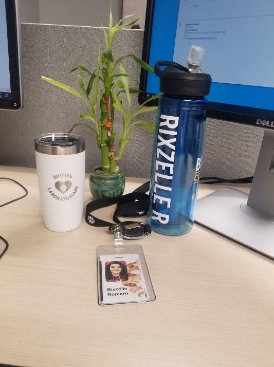 Romero's internship desk with ID badge and water bottle 