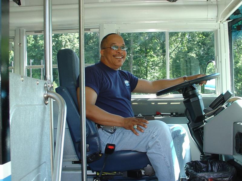 Steve Green smiling in the driver's seat of the Blue Bus