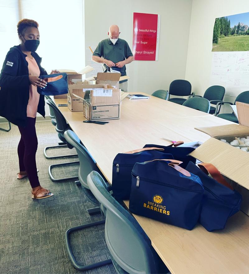 Image of Deans Nixon and Heyduk putting together welcome care packages for incoming Breaking Barriers students
