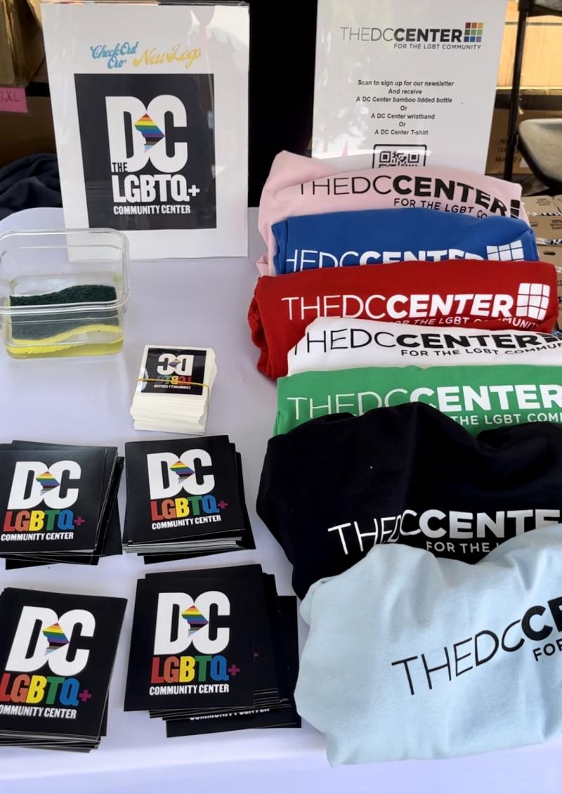 Booth with cup sleeves and t shirt merch from the DC Center for the LGBT Community