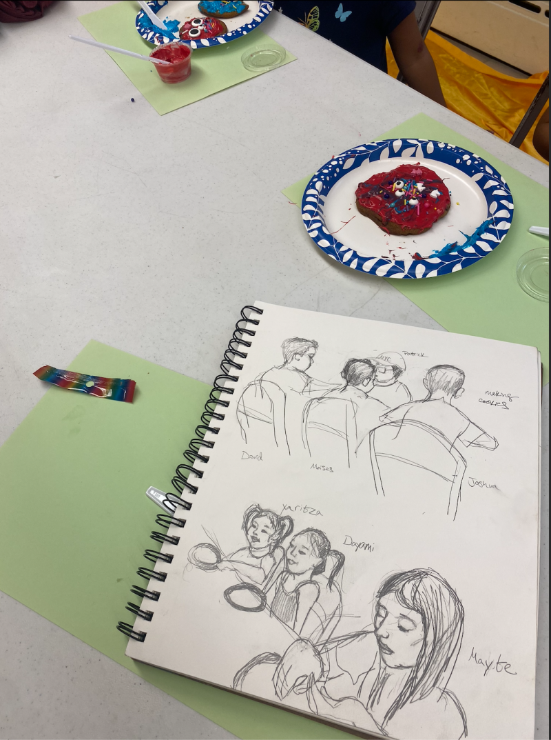 Notebook with drawings and a plate with a cookie. 