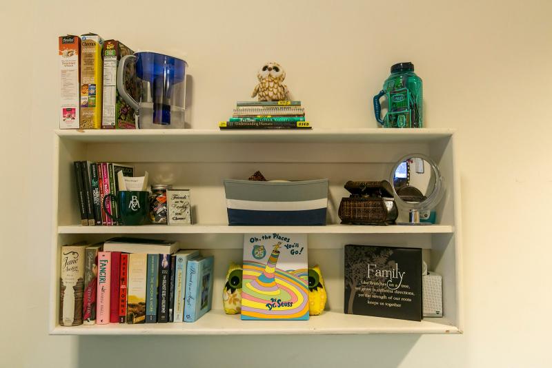 A dorm room shelf with books and other objects