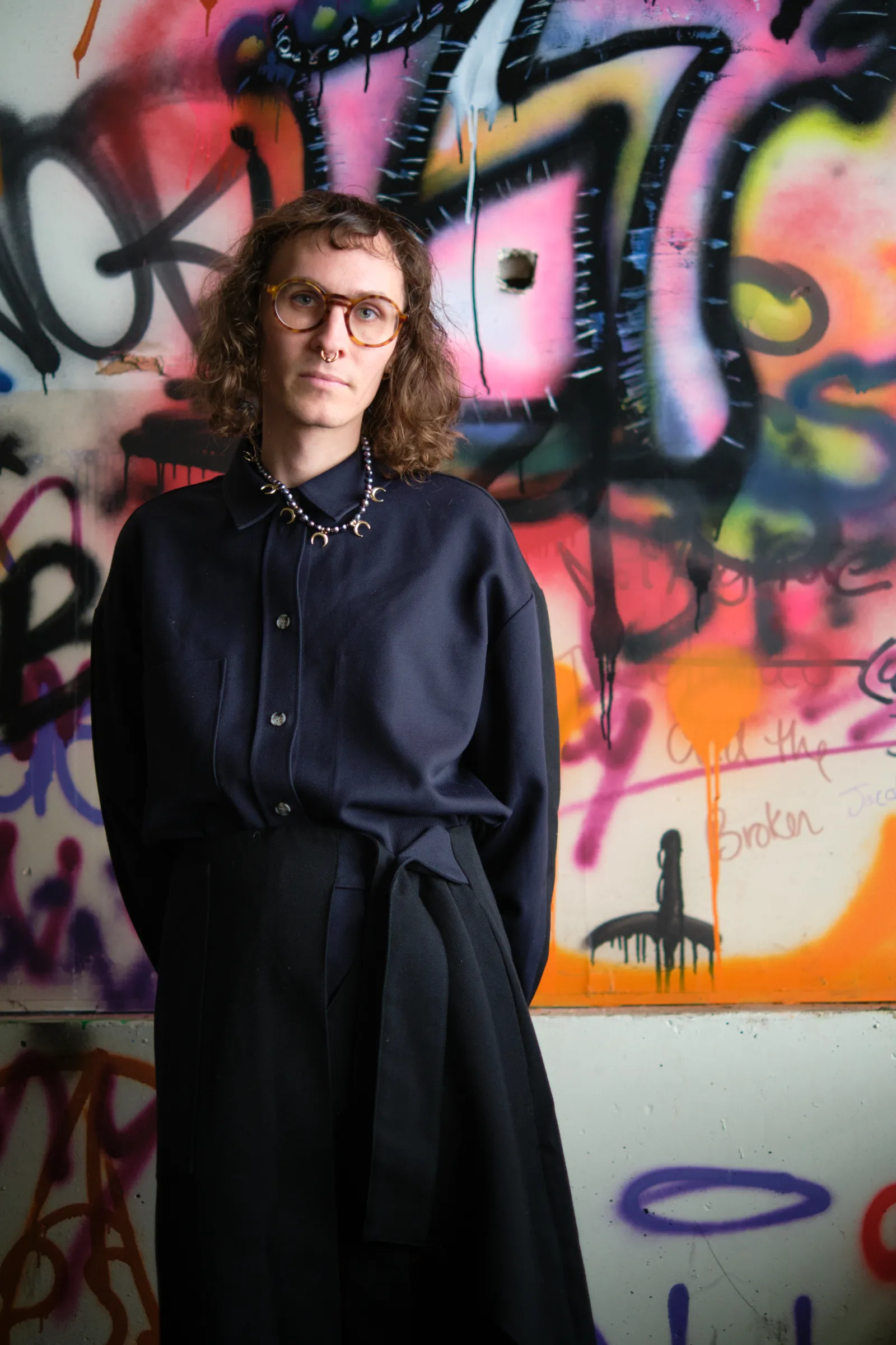 C.C. McKee portrait in front of wall of graffiti