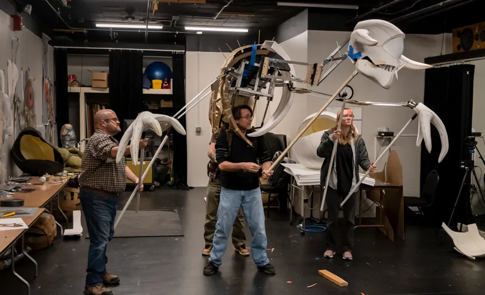 Jeremy Villines, Russ Vick, Jason Hines, and Cricket Bradford test an early iteration of the dragon puppet Fafner for the Atlanta Opera’s production of Siegfried.