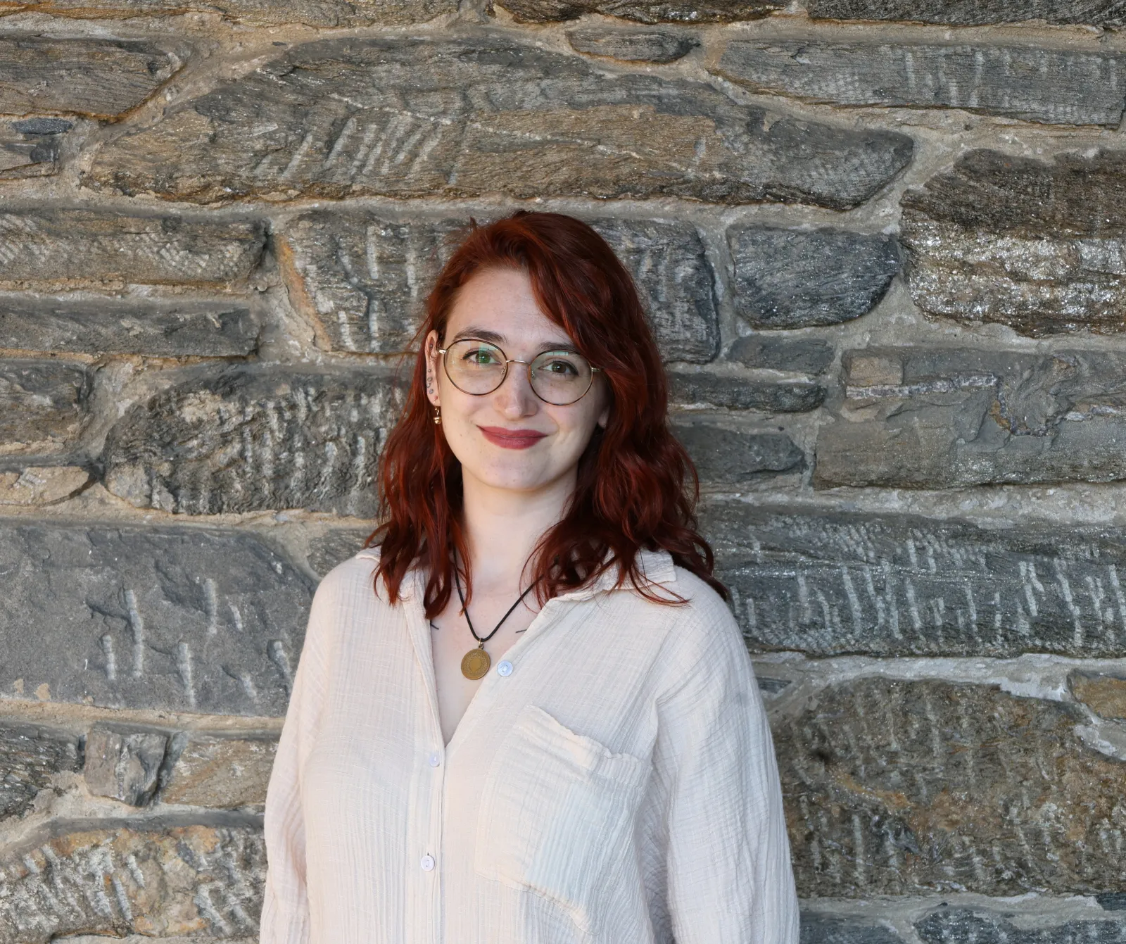 Lily Jones headshot against stone wall.