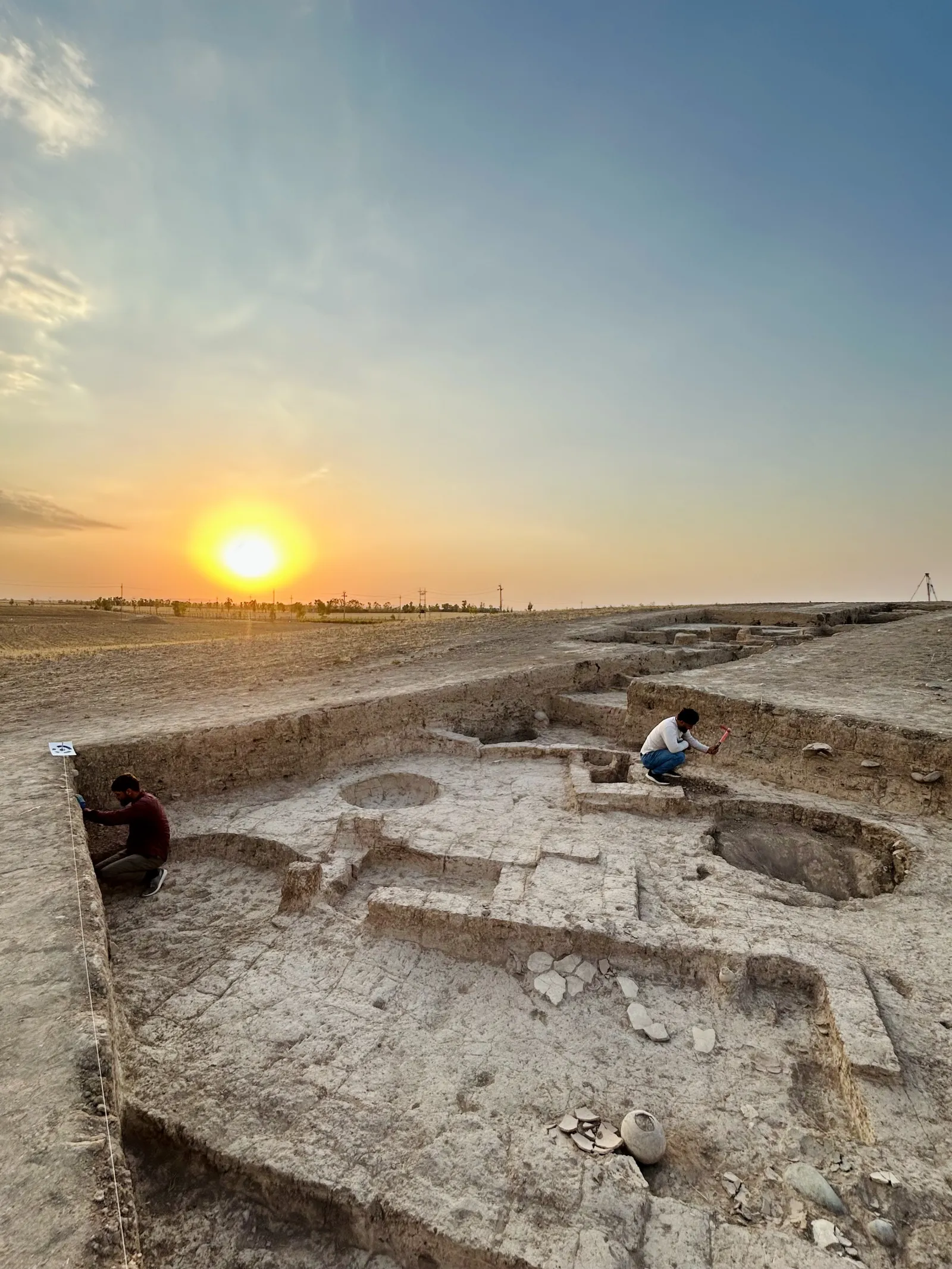 Workers digging at a GMAP site below the setting sun