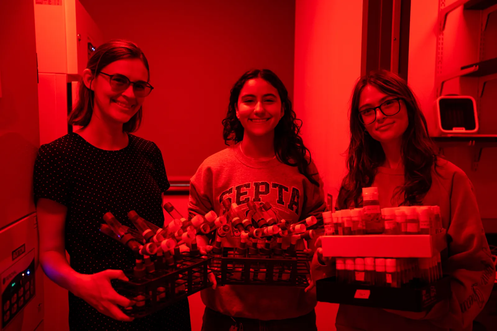 Hannah Shoenhard in her red-lit lab with students
