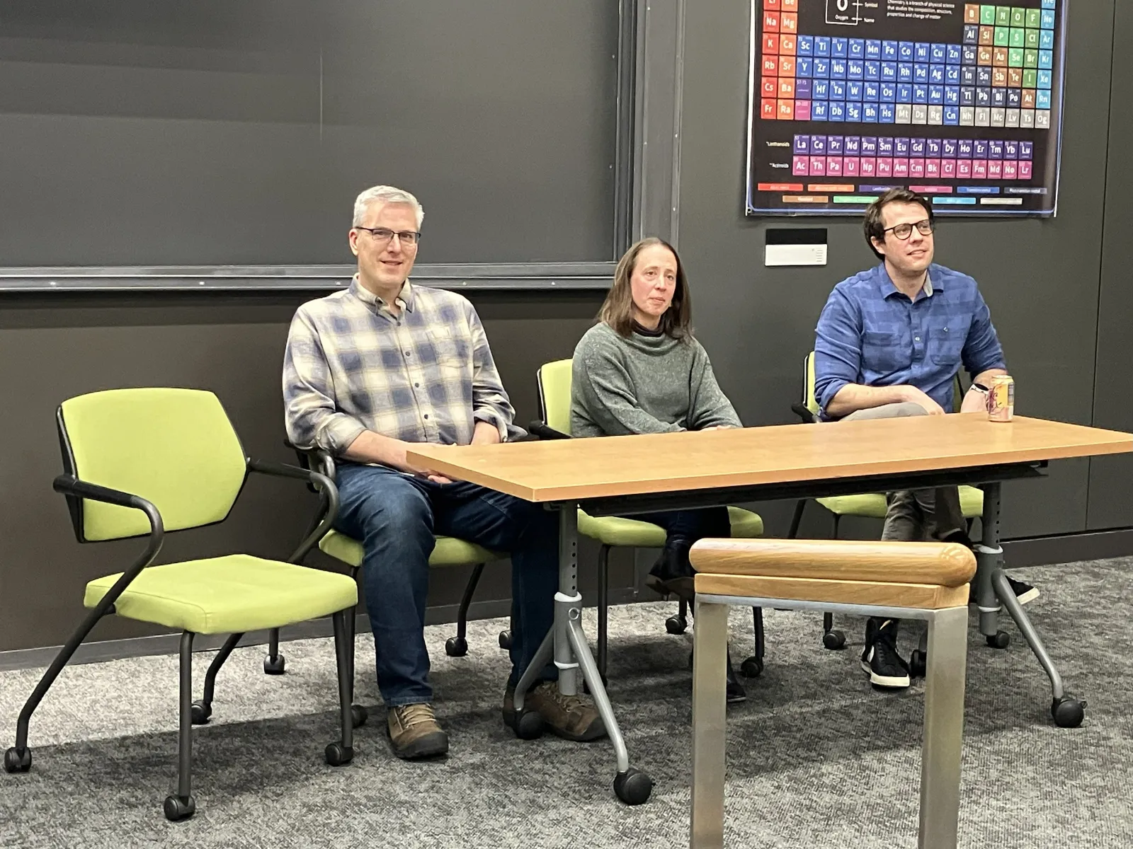 Three people sitting on a panel in a science classroom. 