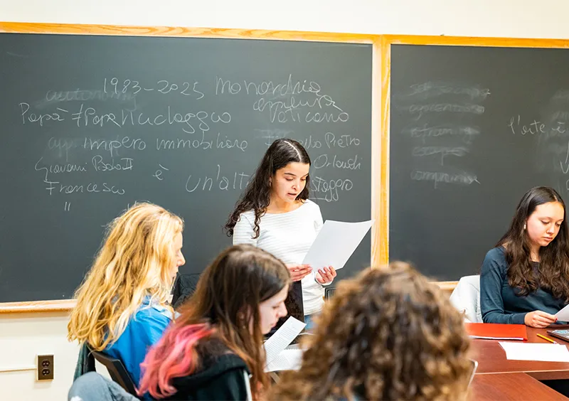 Student speaking in Italian class in front of chalkboard