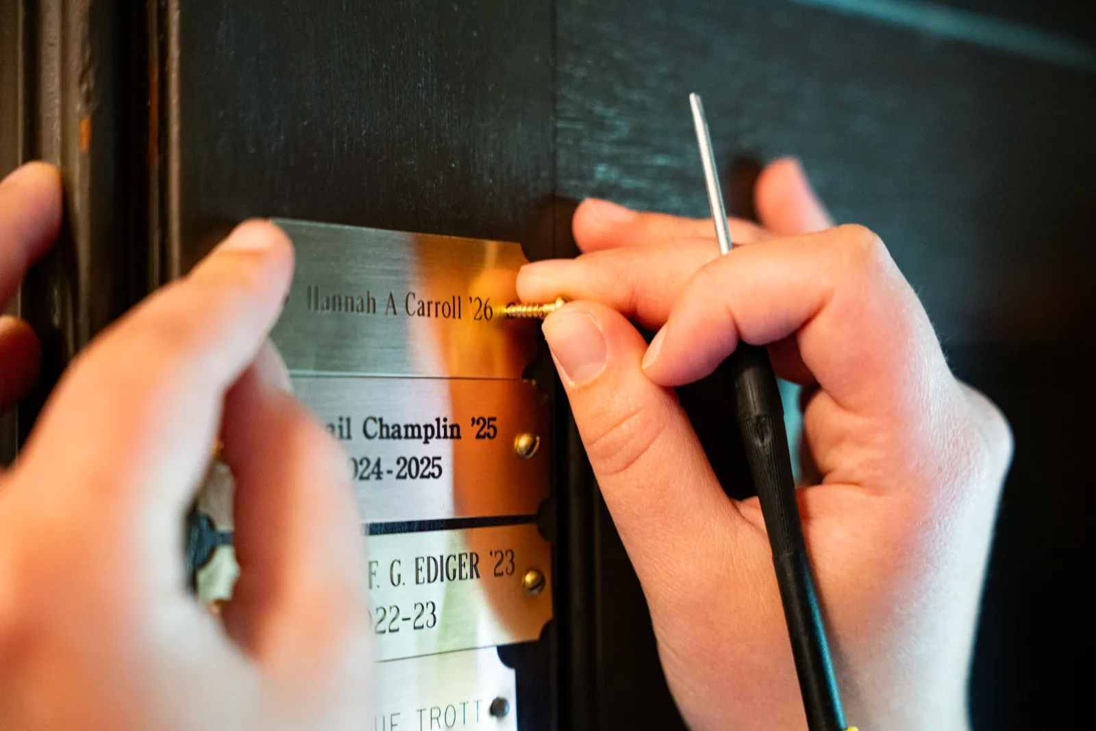 Hannah Carroll installs her brass nameplate