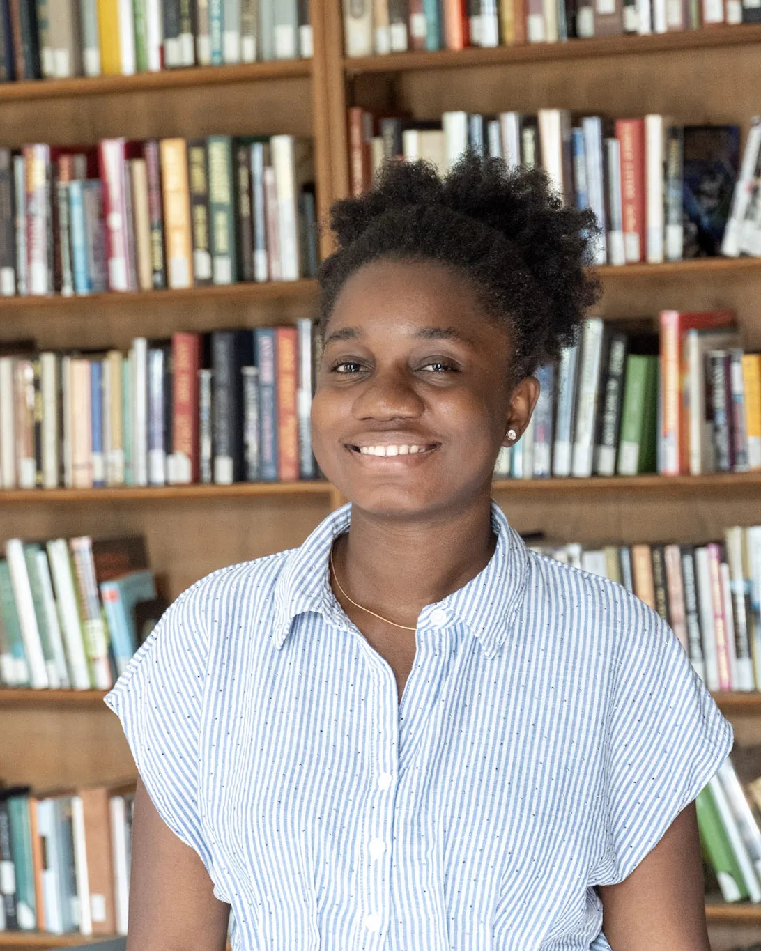 student in front of bookcase
