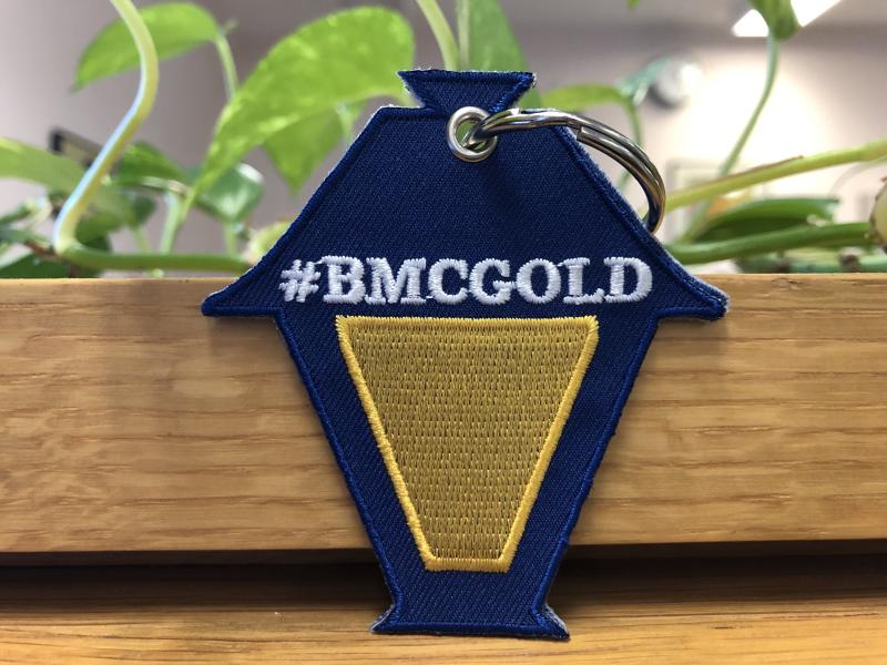 Key chain shaped like a lantern with #BMCGOLD in writing