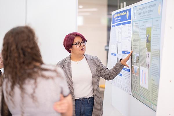 Jocelyn Bravo explains her research at the Summer Science poster session.