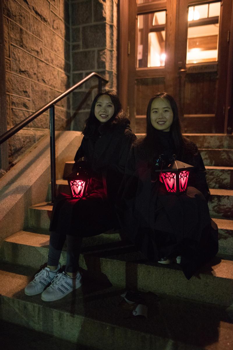Lantern Night 2017 - Two students sitting on Taylor Hall stairs holding red lanterns.