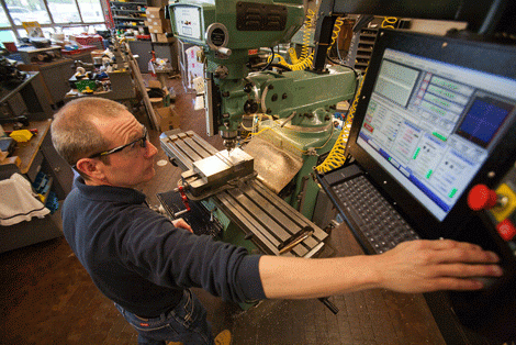 Man wearing safety glasses working with equipment in the machine shop