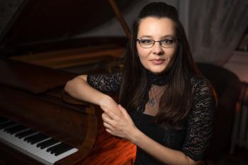 Pianist Katelyn Bouska sits beside a piano
