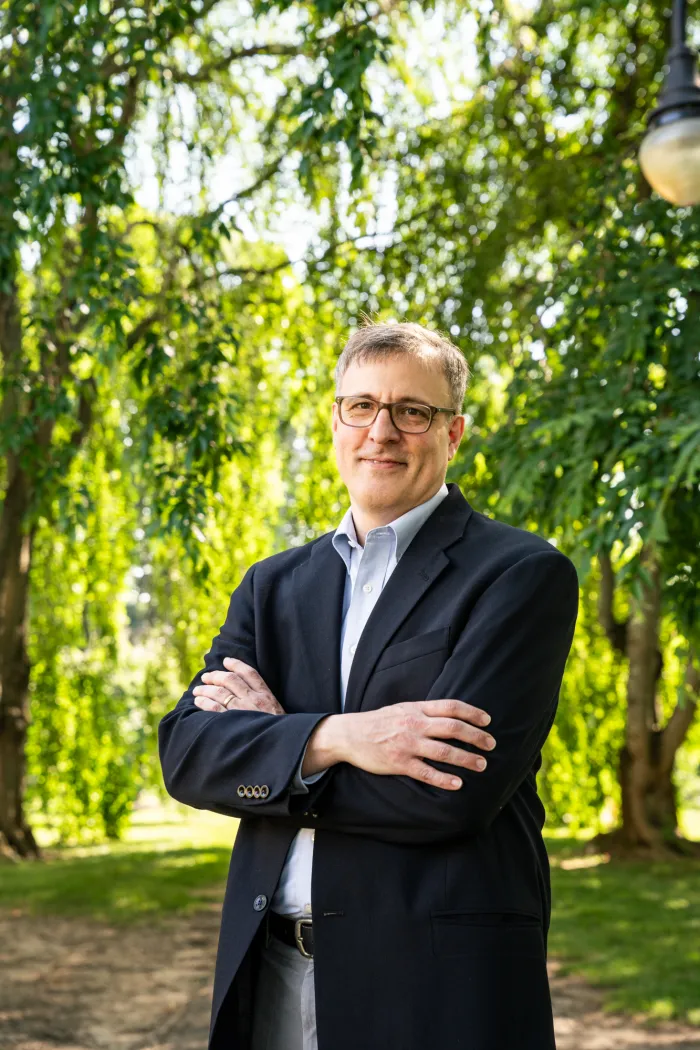 man in dark suit in front of trees